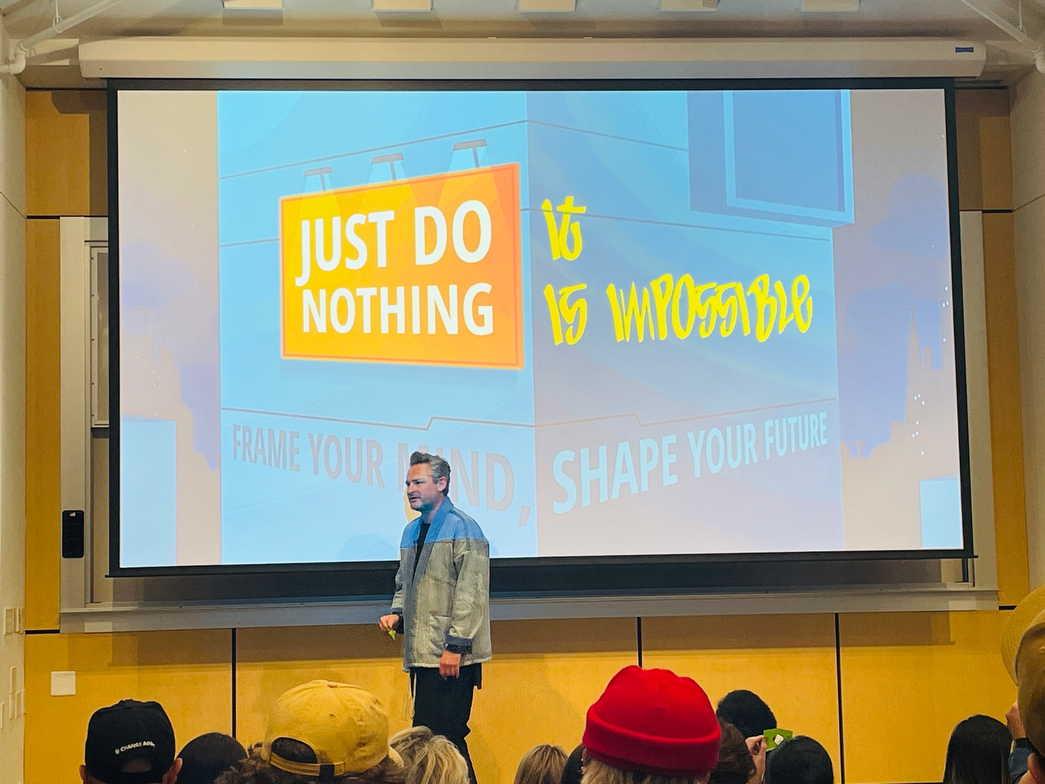 Keynote speaker on stage with 'Frame Your Mind, Shape Your Future' presentation